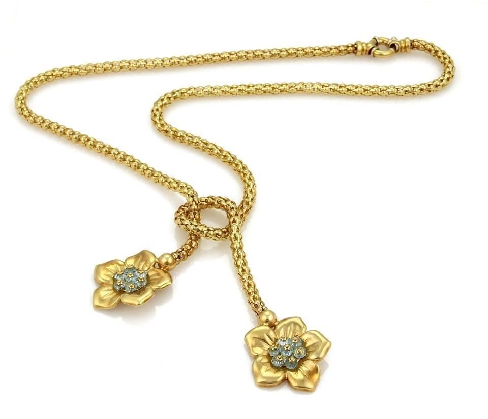 Lariat Necklace with Aquamarine Beads and 18k Yellow Gold Floral Tassels: Lariat Necklace with Aquamarine Beads and 18k Yellow Gold Floral Tassels This vintage lariat necklace features aquamarine beads and 18k yellow gold fancy flex tube elements, accented by two floral tas