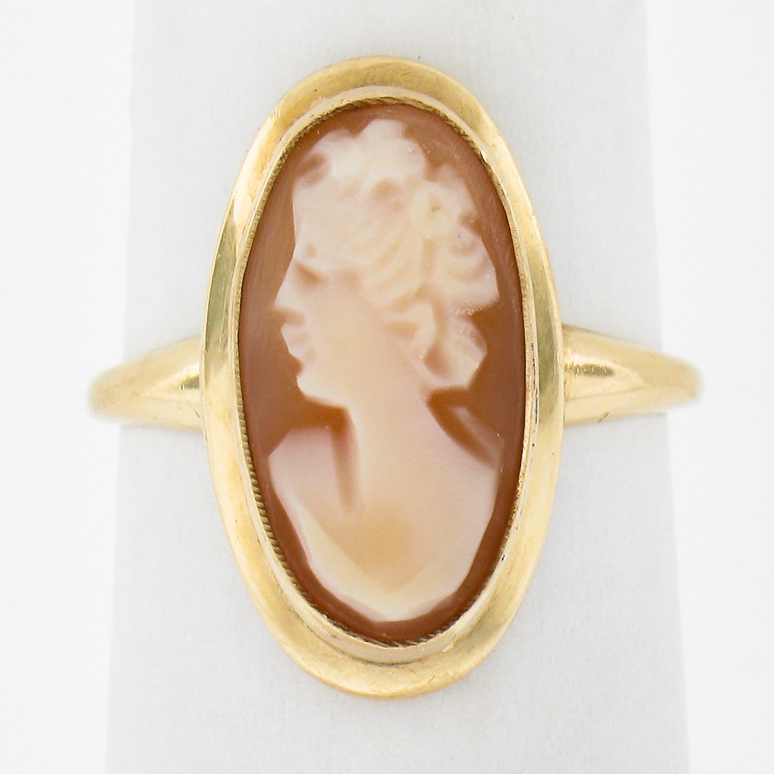 Vintage 10k Yellow Gold Oval Carved Shell Cameo Cocktail Ring: Vintage 10k Yellow Gold Oval Carved Shell Cameo Cocktail Ring This exquisite vintage cocktail ring showcases an elongated oval carved shell cameo, set in solid 10k yellow gold. The centerpiece feature