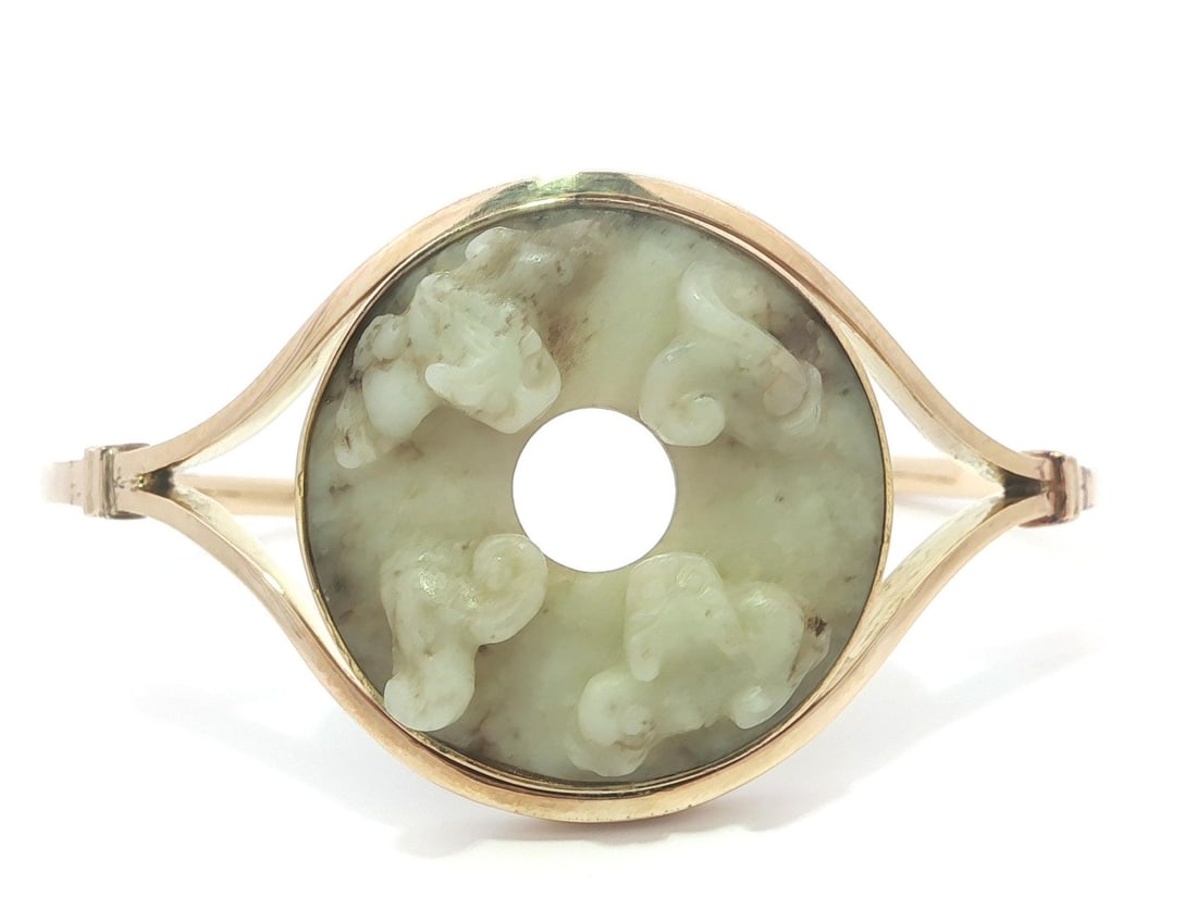 Antique Hand Carved Nephrite Jade Cuff Bracelet in Yellow Gold: Antique Hand Carved Nephrite Jade Cuff Bracelet in Yellow Gold This exquisite antique cuff bangle bracelet features a stunning hand-carved nephrite jade centerpiece, showcasing a beautiful creamy gree