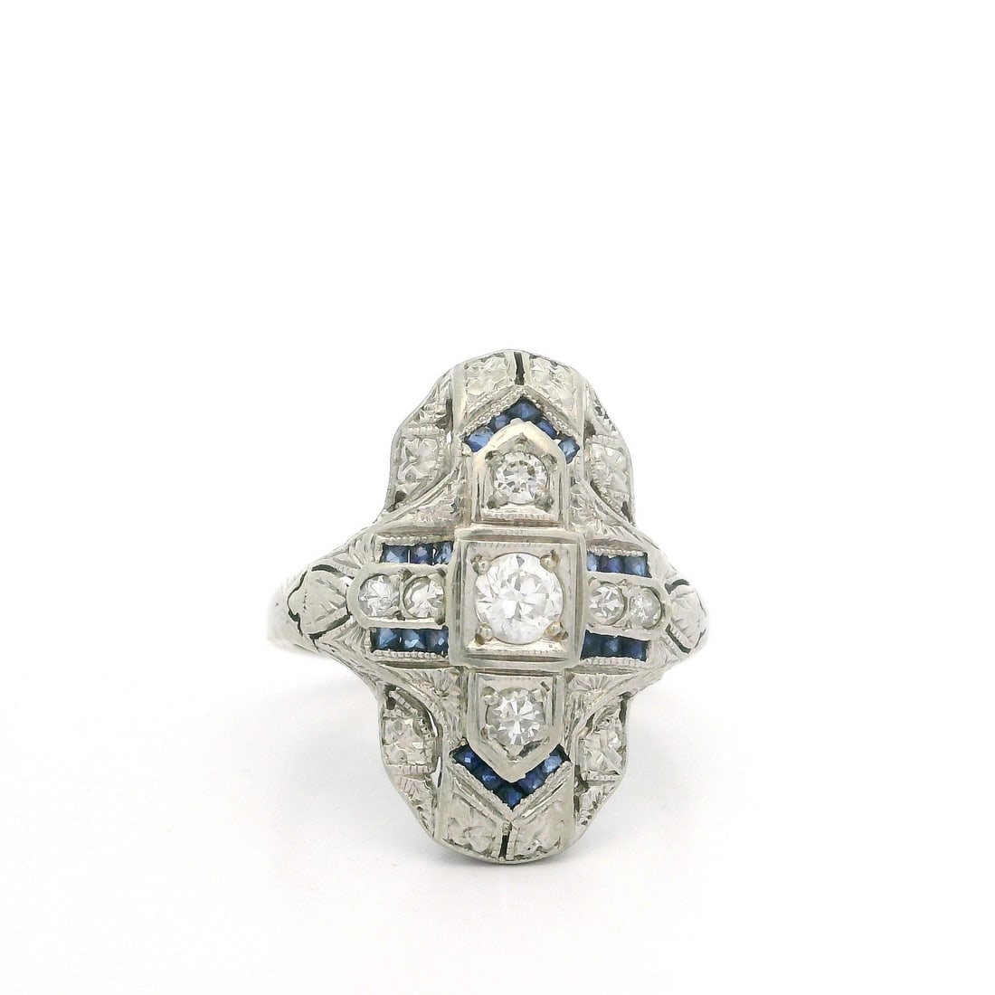 Antique Art Deco White Gold Diamond Sapphire Cocktail Ring: Antique Art Deco White Gold Diamond Sapphire Cocktail Ring This exquisite Antique Art Deco dinner ring showcases a stunning combination of natural diamonds and synthetic sapphires, crafted from solid