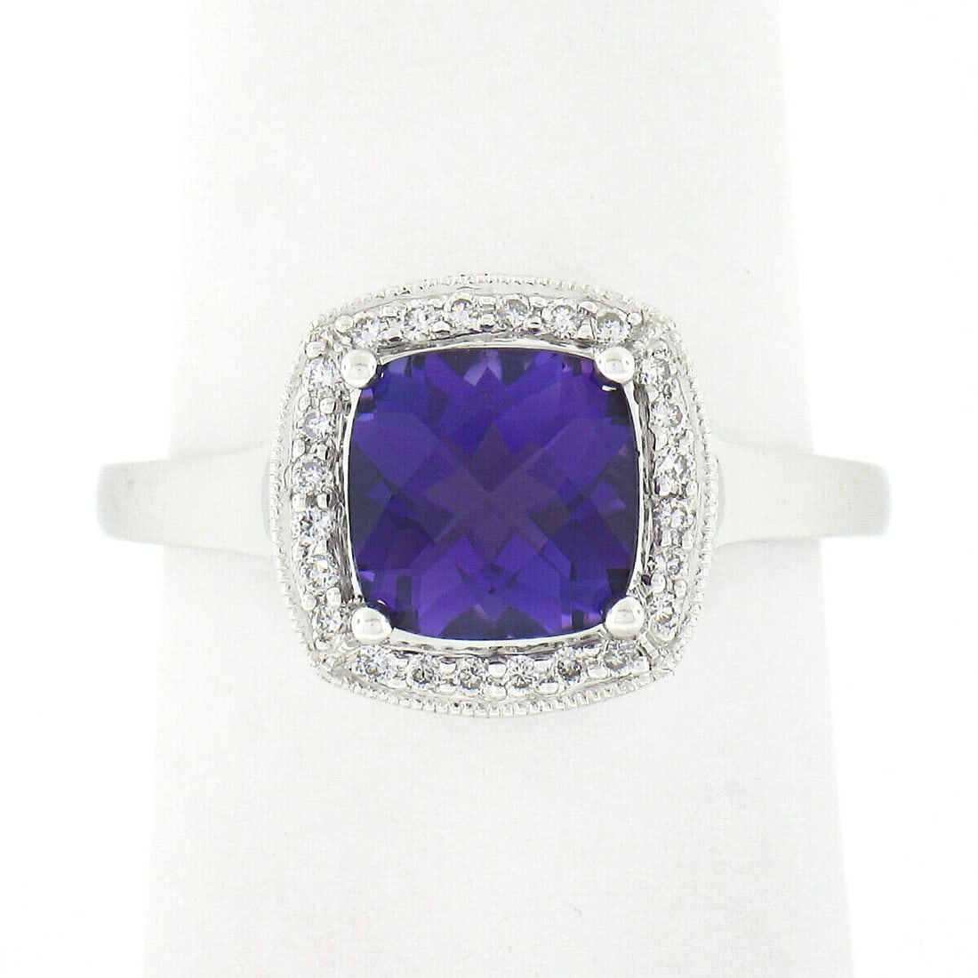 14k White Gold 1.73ctw Amethyst Halo Ring with Diamonds: 14k White Gold 1.73ctw Amethyst Halo Ring with Diamonds This stunning ring features a natural cushion checkerboard cut amethyst, weighing approximately 1.60ct, with a deep purple hue. The gemstone is