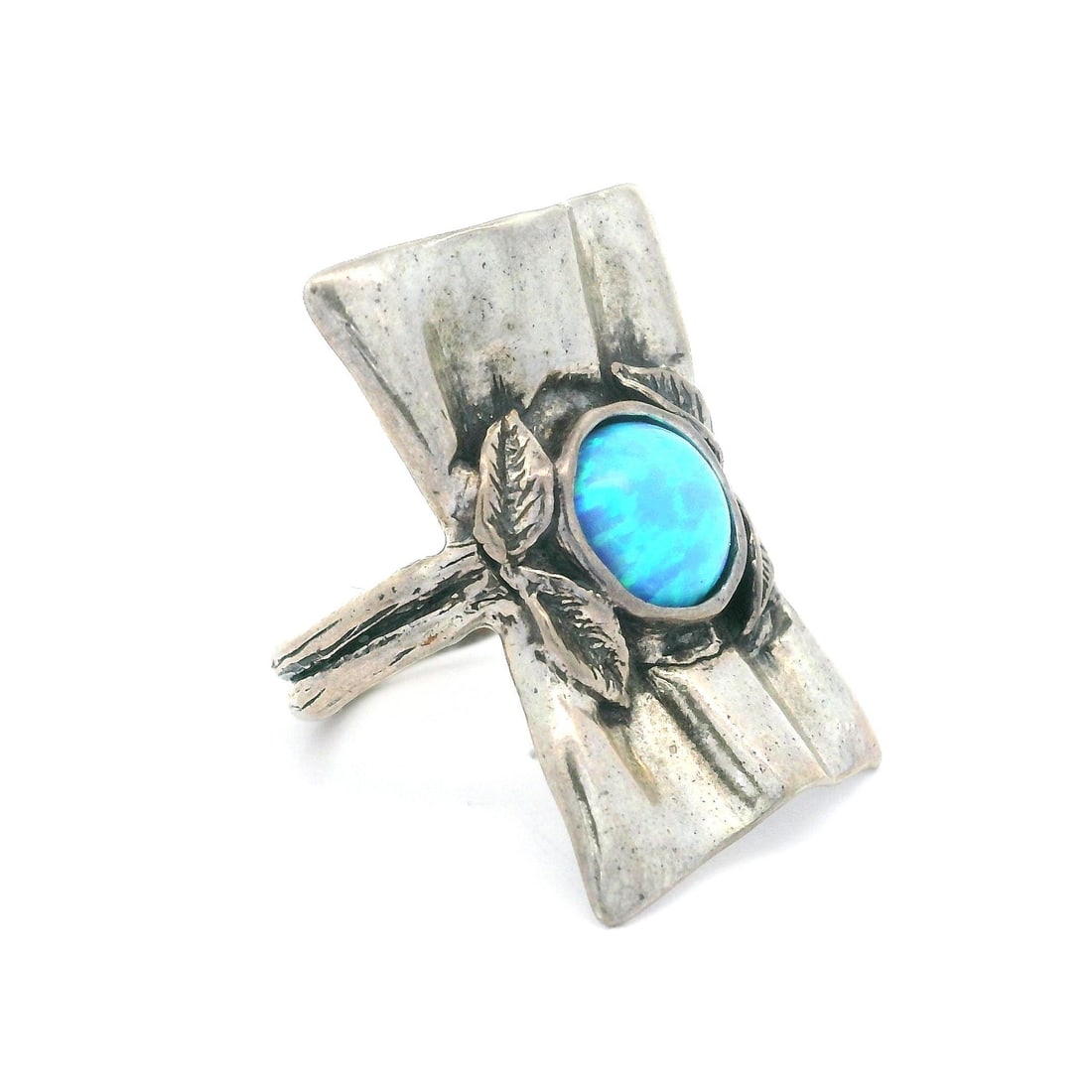 Vintage Sterling Silver Cocktail Ring with Blue Synthetic Opal: Vintage Sterling Silver Cocktail Ring with Blue Synthetic Opal This stunning vintage cocktail ring features a captivating synthetic opal set in a beautifully crafted sterling silver band. The opal sho