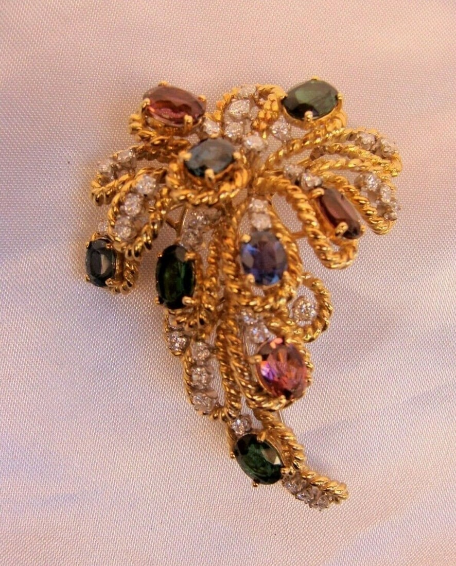 18K Gold Diamond Blue Pink Sapphire Brooch by Jack Gutschneider: 18K Gold Diamond Blue Pink Sapphire Brooch by Jack Gutschneider This exquisite brooch, crafted by Jack Gutschneider, showcases a stunning combination of 18K yellow gold, diamonds, blue sapphires, pink