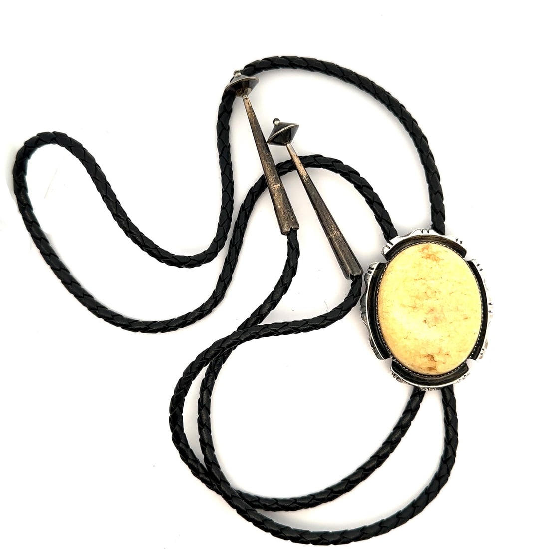 Dan Nieto Sterling Silver Yellow Cabochon Bolo Tie with Black Leather: Dan Nieto Sterling Silver Yellow Cabochon Bolo Tie with Black Leather This stunning bolo tie features a striking yellow oval cabochon set in a sterling silver pendant. The warm yellow stone is securel