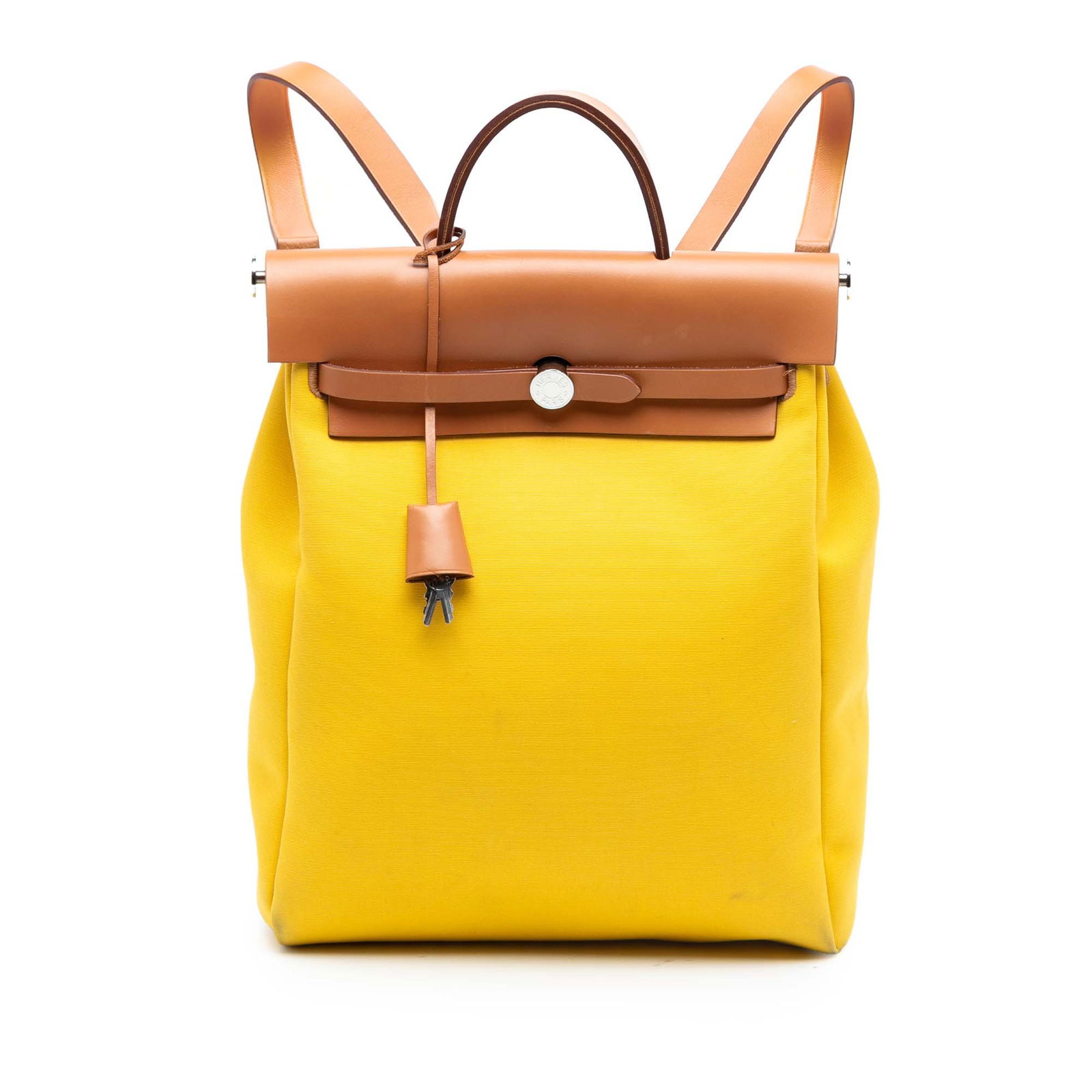 Yellow Fabric Herbag A Dos Zip Retourne Backpack by Hermes: Yellow Fabric Herbag A Dos Zip Retourne Backpack by Hermes The Hermes Toile Herbag A Dos Zip Retourne Backpack features a durable canvas body with a flat leather top handle and adjustable leather back