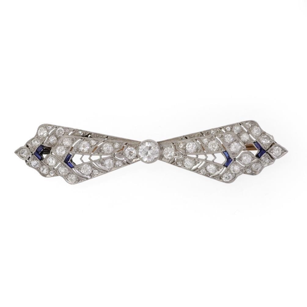 Art Deco Platinum Gold Diamond Blue Stone Double Layered Bow Pin: Art Deco Platinum Gold Diamond Blue Stone Double Layered Bow Pin This exquisite Art Deco pin showcases a stunning double layered bow design, meticulously crafted from platinum. The centerpiece feature