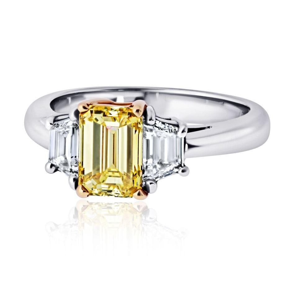 Three Stone Platinum and 18K Gold Ring with 1.32ct GIA Intense Yellow Emerald Diamond: Three Stone Platinum and 18K Gold Ring with 1.32ct GIA Intense Yellow Emerald Diamond This exquisite three-stone engagement ring features a stunning 1.32 carat Emerald Cut diamond at its center, certi