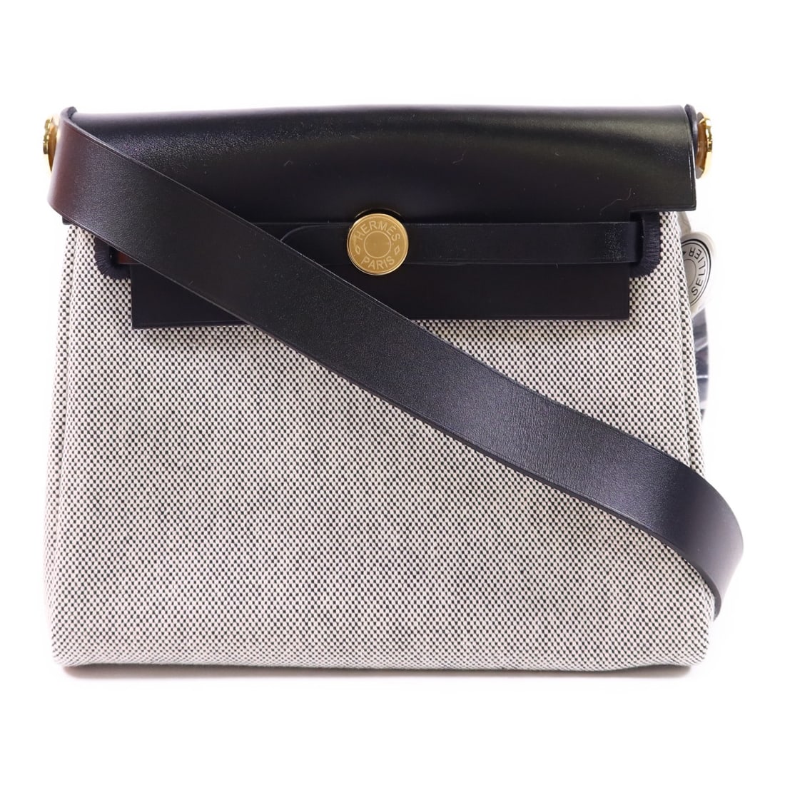 Mini Herbag black canvas shoulder bag with gold hardware by Hermes: Mini Herbag black canvas shoulder bag with gold hardware by Hermes This Hermes Mini Herbag shoulder bag features a black canvas exterior and a classic design. Crafted in France, it offers a compact an