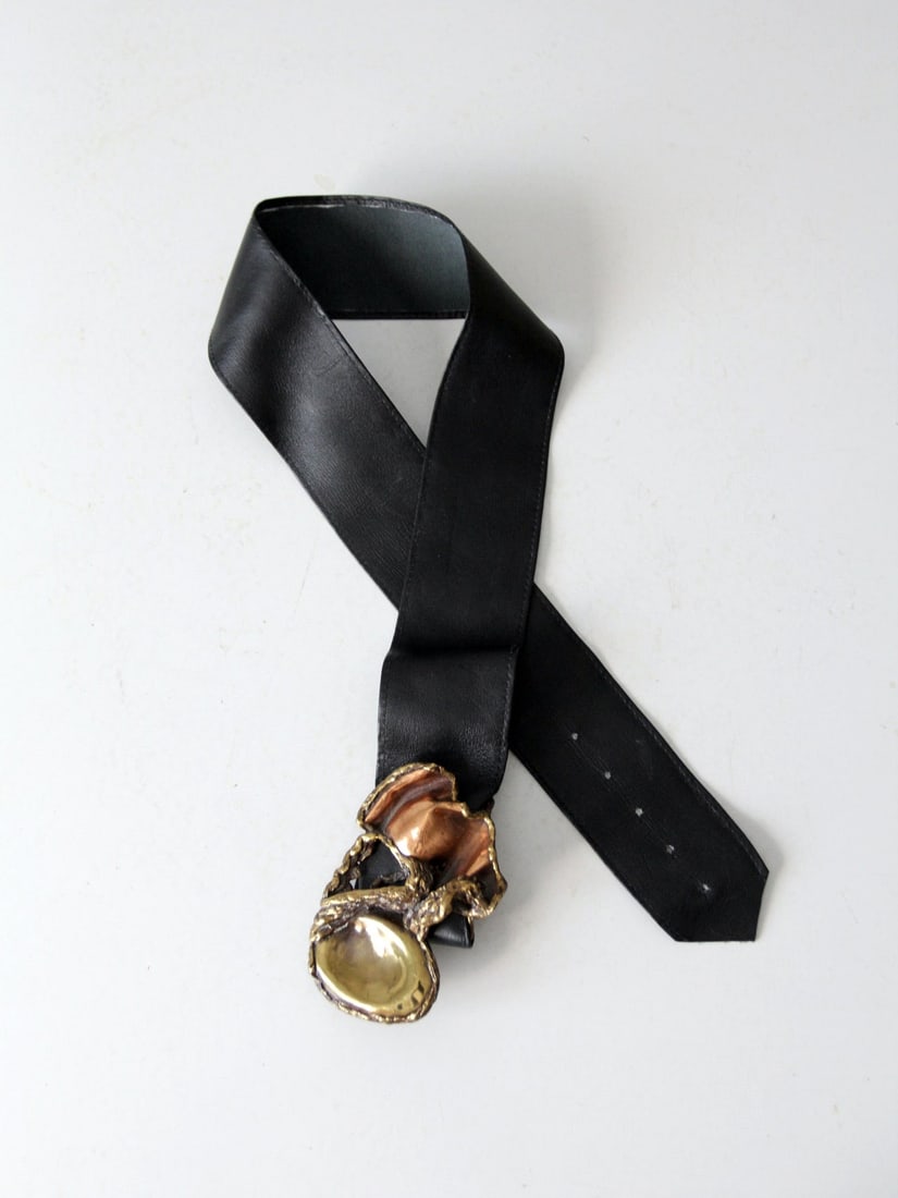 Black Wide Vintage Belt With Exan Mexican Brutalist Mixed Metal Buckle: Black Wide Vintage Belt With Exan Mexican Brutalist Mixed Metal Buckle This vintage black wide belt features a bold, sculptural mixed metal buckle in a brutalist design, handcrafted in Mexico. The bel