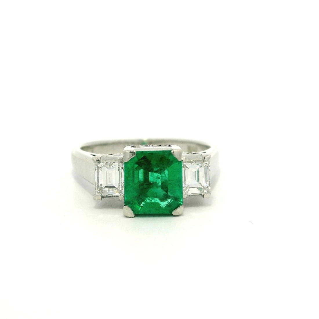 GIA Certified 1.57ct Platinum Emerald Diamond 3 Stone Ring: GIA Certified 1.57ct Platinum Emerald Diamond 3 Stone Ring This exquisite three-stone ring features a stunning natural emerald at its center, flanked by two brilliant natural diamonds. The emerald is