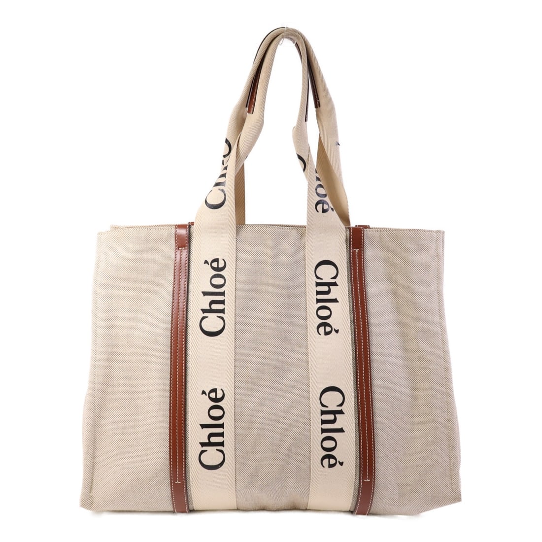 Woody Large Canvas Tote in Brown by Chloe: Woody Large Canvas Tote in Brown by Chloe This Chloe Woody large tote bag is crafted from brown canvas and offers a spacious interior, making it ideal for everyday use. Made in France, it features a c