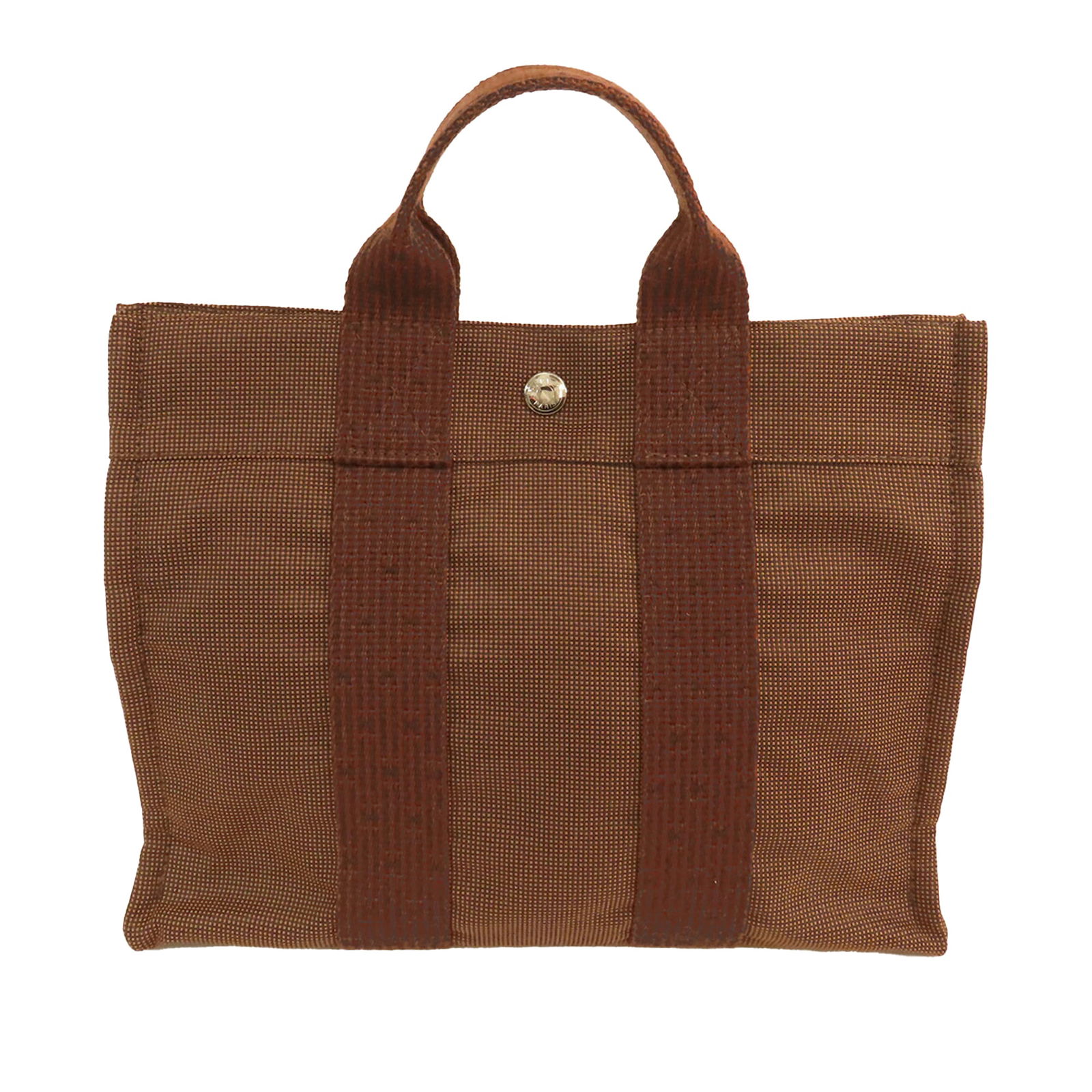 Brown Herline PM Tote Bag by Hermes in Canvas Fabric: Brown Herline PM Tote Bag by Hermes in Canvas Fabric The Hermes Herline PM is a brown canvas bag featuring flat straps, an open top with a snap closure, and an interior zip compartment. The exterior a