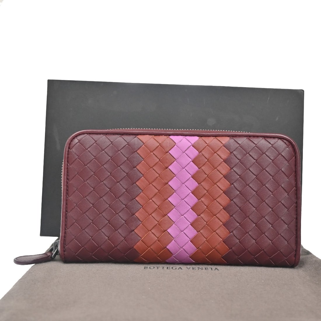 Bottega Veneta Burgundy Leather Intrecciato Zip Around Long Wallet: Bottega Veneta Burgundy Leather Intrecciato Zip Around Long Wallet This Bottega Veneta Intrecciato Long Zip Wallet is crafted from burgundy leather and features the brand's signature woven design. Des