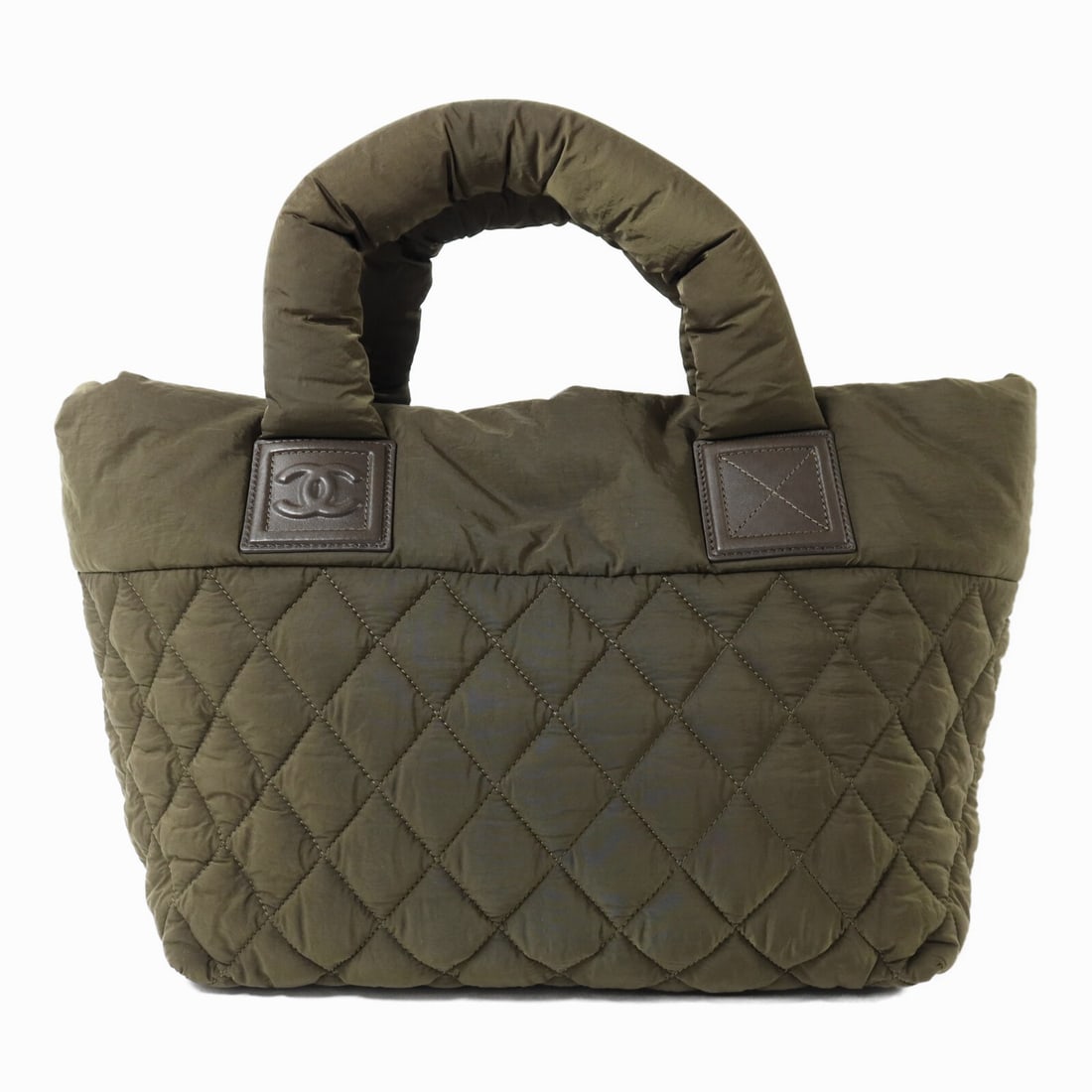 Green Nylon Coco Cocoon Handbag by CHANEL with Silver CC Hardware: Green Nylon Coco Cocoon Handbag by CHANEL with Silver CC Hardware This CHANEL Coco Cocoon handbag features a green nylon exterior with silver-tone hardware. The bag offers a regular size with ample sp