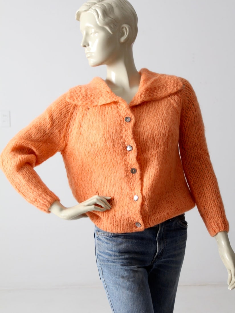 1950s Famelia Mohair Cardigan Soft Peach Vintage Italy: 1950s Famelia Mohair Cardigan Soft Peach Vintage Italy This charming 1950s vintage mohair cardigan is crafted in Italy by Famelia. The ultra-soft piece features pearly gray button closures and a wide