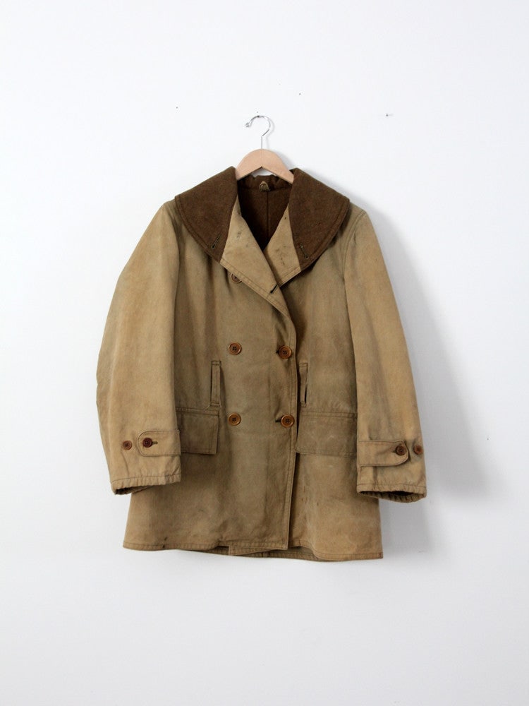 Vintage American Army Double Breasted Coat with Wool Lining: Vintage American Army Double Breasted Coat with Wool Lining This vintage American army coat is a standout piece from our Stylist's Collection. Crafted from sturdy tan canvas, it features a thick olive