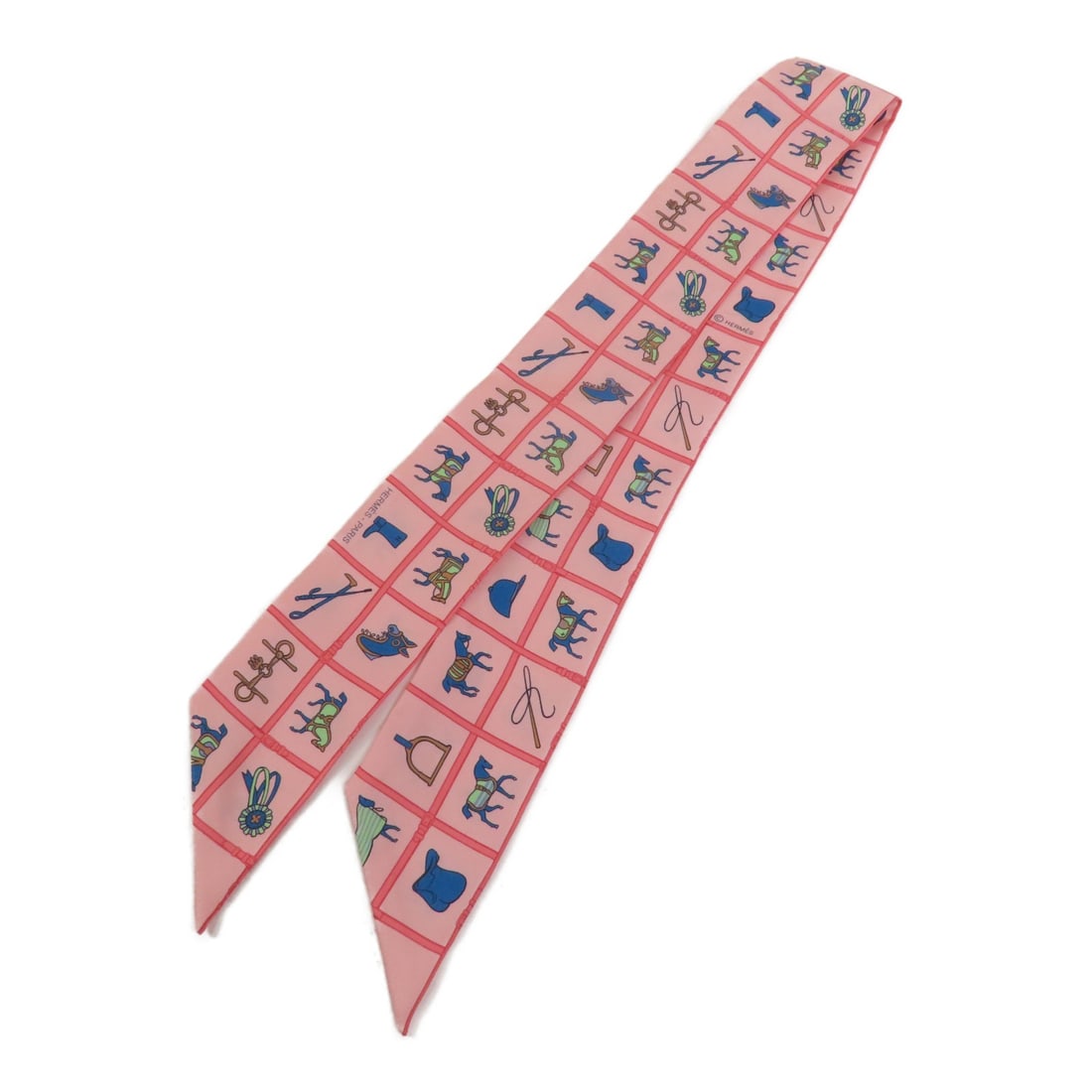 HERMES Pink Silk Twilly Scarf Made in France: HERMES Pink Silk Twilly Scarf Made in France Elevate your accessory collection with this exquisite HERMES Twilly Scarf. Crafted from luxurious silk, this scarf features a vibrant pink color that adds