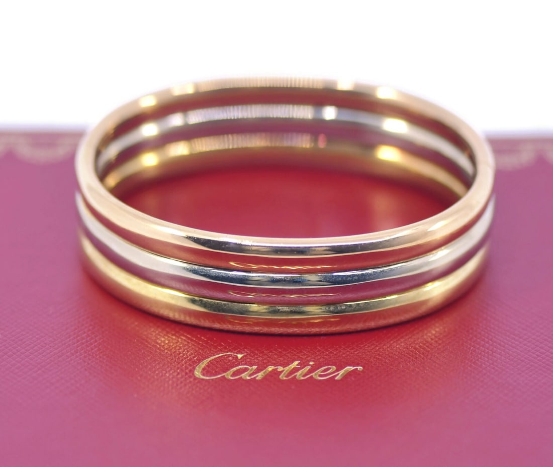 Cartier Trinity 18K Tri-Color Gold Bangle Bracelet Authentic: Cartier Trinity 18K Tri-Color Gold Bangle Bracelet Authentic This elegant Cartier Trinity bracelet features a classic bangle design crafted from 18K tri-color gold, showcasing a harmonious blend of ye