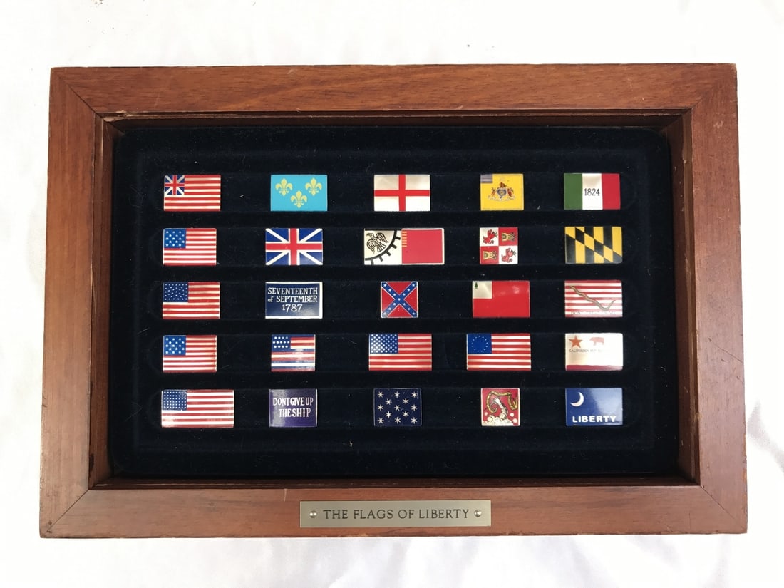 25 Piece Enameled Sterling Silver Flags of Liberty Collection in Box: 25 Piece Enameled Sterling Silver Flags of Liberty Collection in Box Discover this exquisite collection of 25 enameled sterling silver Flags of Liberty, elegantly presented in a wooden box with a plaq