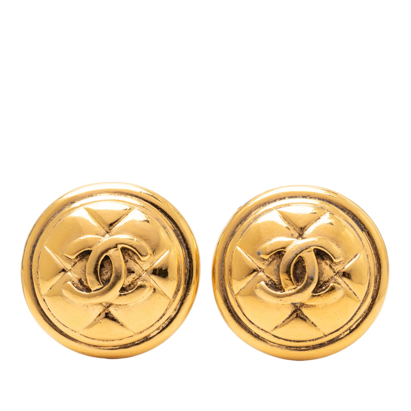 Chanel Quilted CC Gold Tone Clip On Round Earrings: Chanel Quilted CC Gold Tone Clip On Round Earrings These Chanel earrings feature a round, quilted design with the iconic CC logo, crafted from gold tone metal. They are designed with clip-on closures.