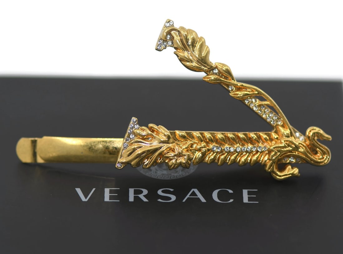 Versace 78mm Gold Tone Hair Accessory Pin: Versace 78mm Gold Tone Hair Accessory Pin This is a pre-owned Versace hair pin featuring a gold-plated finish. The elegant accessory measures 78mm in length and weighs 23.5 grams, showcasing the signa
