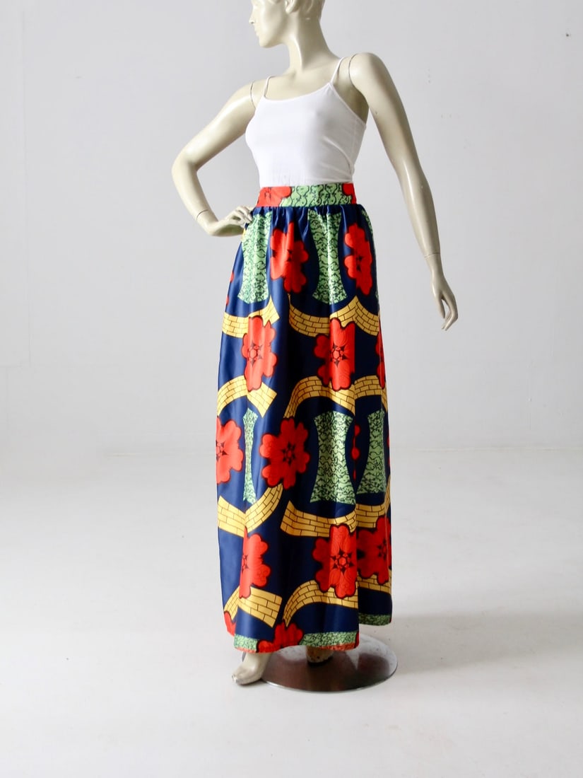 1970s Vintage Maxi Skirt Tropical Floral Print with Pockets: 1970s Vintage Maxi Skirt Tropical Floral Print with Pockets This stunning 1970s vintage maxi skirt showcases a beautiful tropical floral print that gracefully falls to the floor. The skirt features a