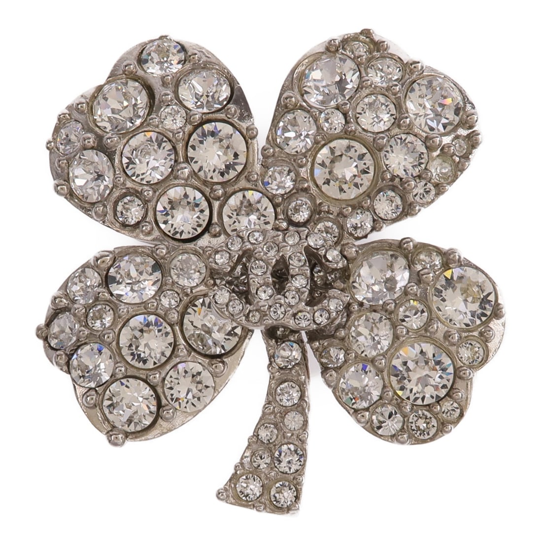 Silver Metal Brooch with CC Emblem from CHANEL: Silver Metal Brooch with CC Emblem from CHANEL This CHANEL CC brooch features a distinctive silver-tone metal design with clear accents. Crafted in France, the brooch showcases the iconic CC logo and