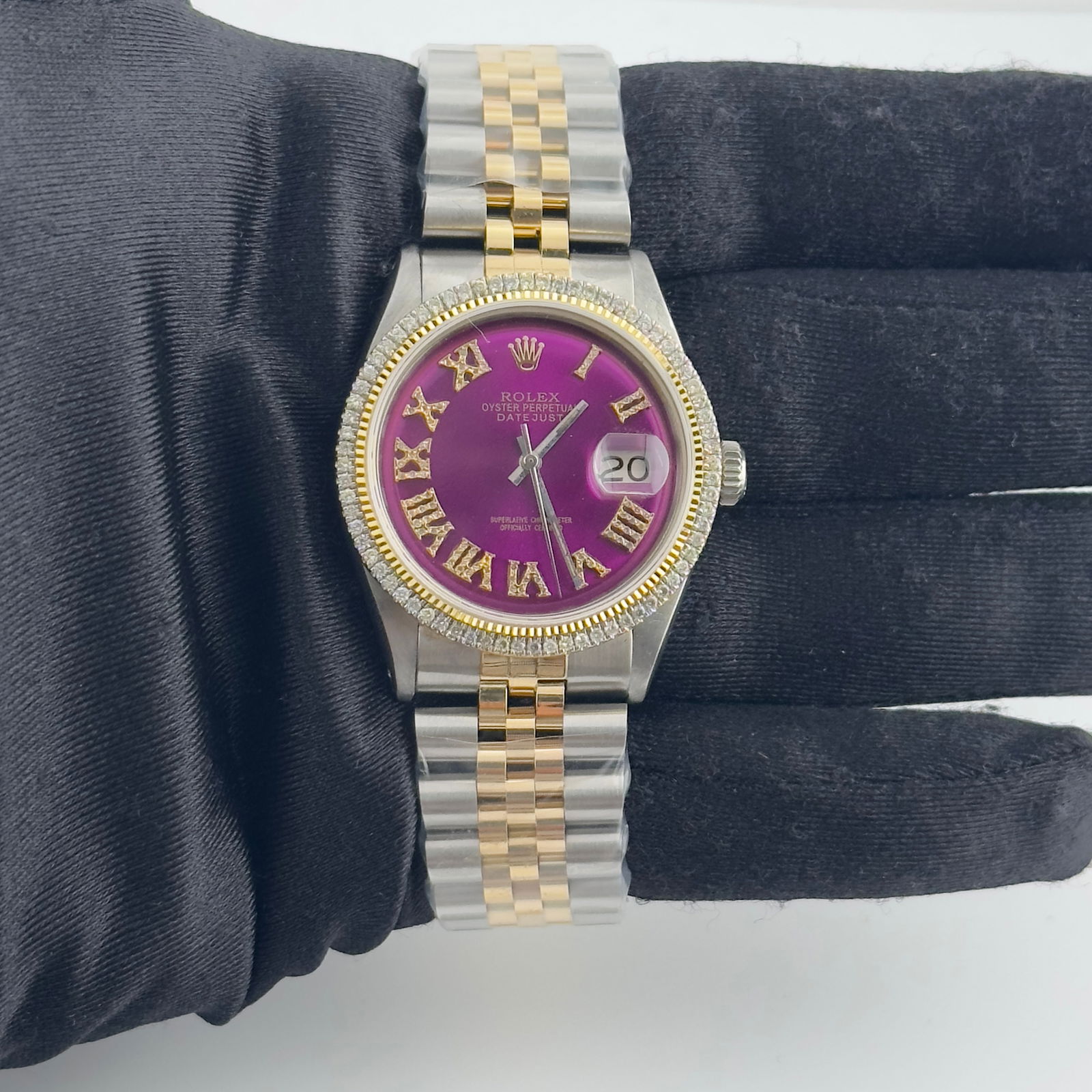 AM Purple Roman Dial Jubilee Bracelet Rolex Datejust Ref 1601: AM Purple Roman Dial Jubilee Bracelet Rolex Datejust Ref 1601 This Rolex Datejust features an aftermarket purple Roman numeral dial and an aftermarket Jubilee bracelet. The timepiece includes a prong