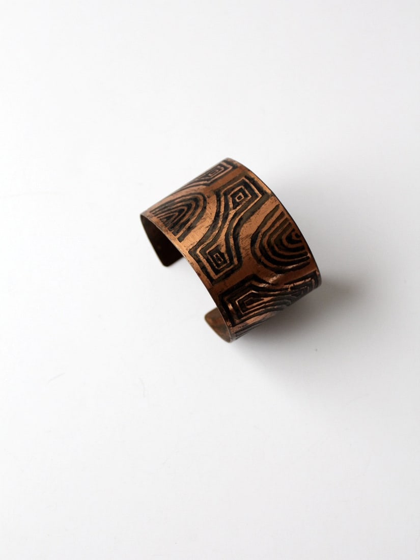 Artist Signed Vintage Copper Cuff Bracelet with Geometric Design: Artist Signed Vintage Copper Cuff Bracelet with Geometric Design Discover a stunning piece from our Stylist's Collection: a vintage signed copper cuff bracelet. This remarkable cuff showcases an artis
