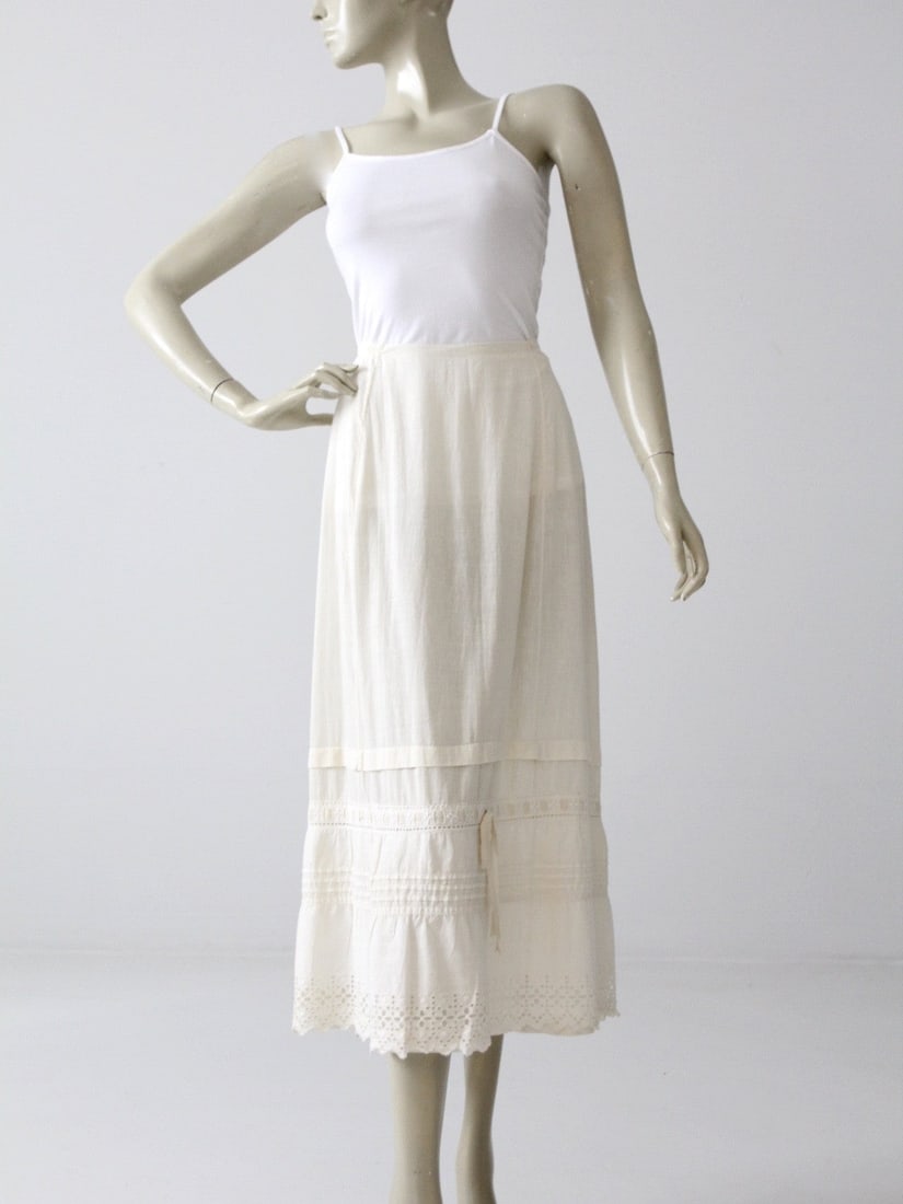 Vintage 1900s Cream Cotton Petticoat Skirt with Lace Details: Vintage 1900s Cream Cotton Petticoat Skirt with Lace Details Discover an exquisite piece from the 1900s with this Antique Petticoat Skirt. Crafted from cream cotton, this slip skirt features delicate