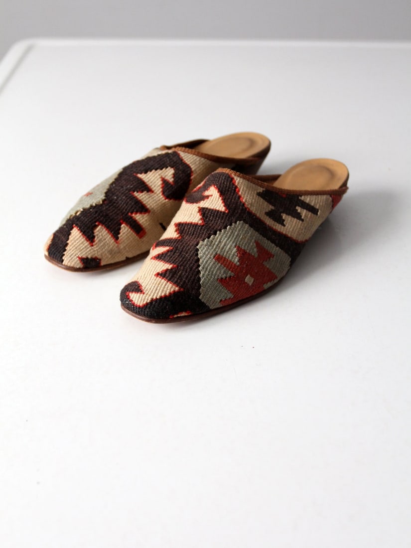 Chic Vintage Kilim Mules Turkish Slides Size 8: Chic Vintage Kilim Mules Turkish Slides Size 8 Step into comfort and style with these Vintage Kilim Mules from The Nomadic Collection. Crafted in Turkey, these chic slides showcase stunning kilim wool