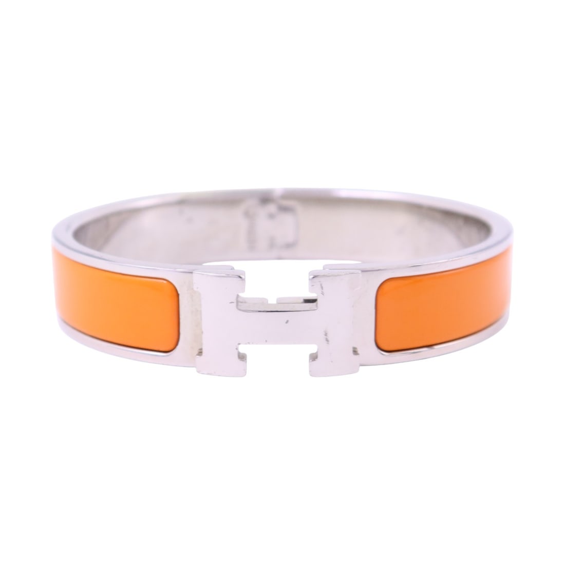 Clic H Orange Enamel Bracelet with Palladium Hardware by Hermes: Clic H Orange Enamel Bracelet with Palladium Hardware by Hermes This Hermes Clic H bangle bracelet features an orange enamel exterior with metal accents in a palladium tone. The bracelet has a sleek,