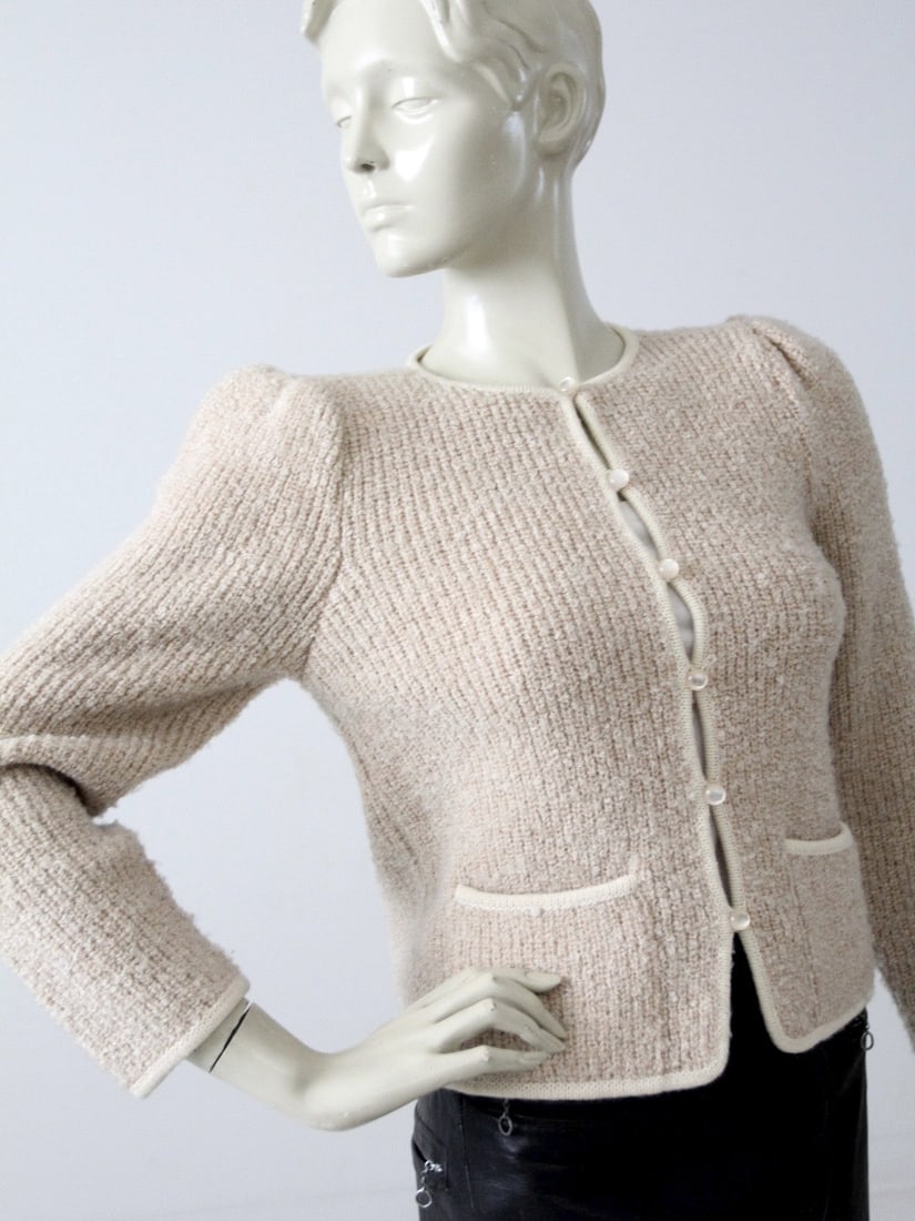 Vintage 70s Pale Pink Boucle Cardigan Jacket with Iridescent Buttons: Vintage 70s Pale Pink Boucle Cardigan Jacket with Iridescent Buttons Embrace vintage elegance with this late 70s boucle cardigan jacket. Crafted from a soft blend of 75% acrylic and 25% wool, this pal