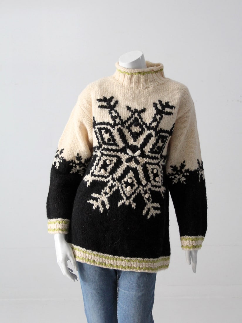 Vintage Hand Knit Snowflake Sweater with Puff-Ball Accents: Vintage Hand Knit Snowflake Sweater with Puff-Ball Accents This vintage hand-knit sweater showcases an adorable snowflake design adorned with puff-ball accents. Crafted from a cozy wool (or wool blend