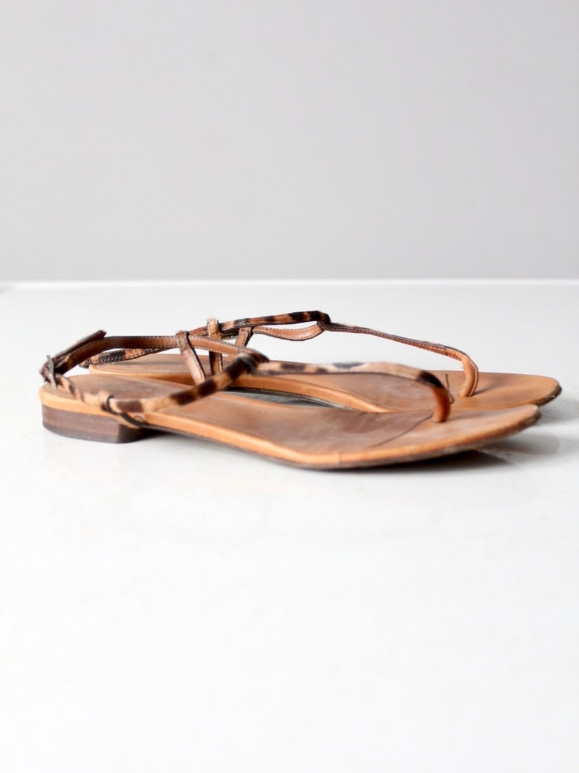 Dolce & Gabbana Leopard Pony Skin Thong Sandals with Adjustable Ankle Straps: Dolce & Gabbana Leopard Pony Skin Thong Sandals with Adjustable Ankle Straps These vintage Dolce & Gabbana sandals feature a leopard print pony skin thong design with adjustable ankle straps and buckl