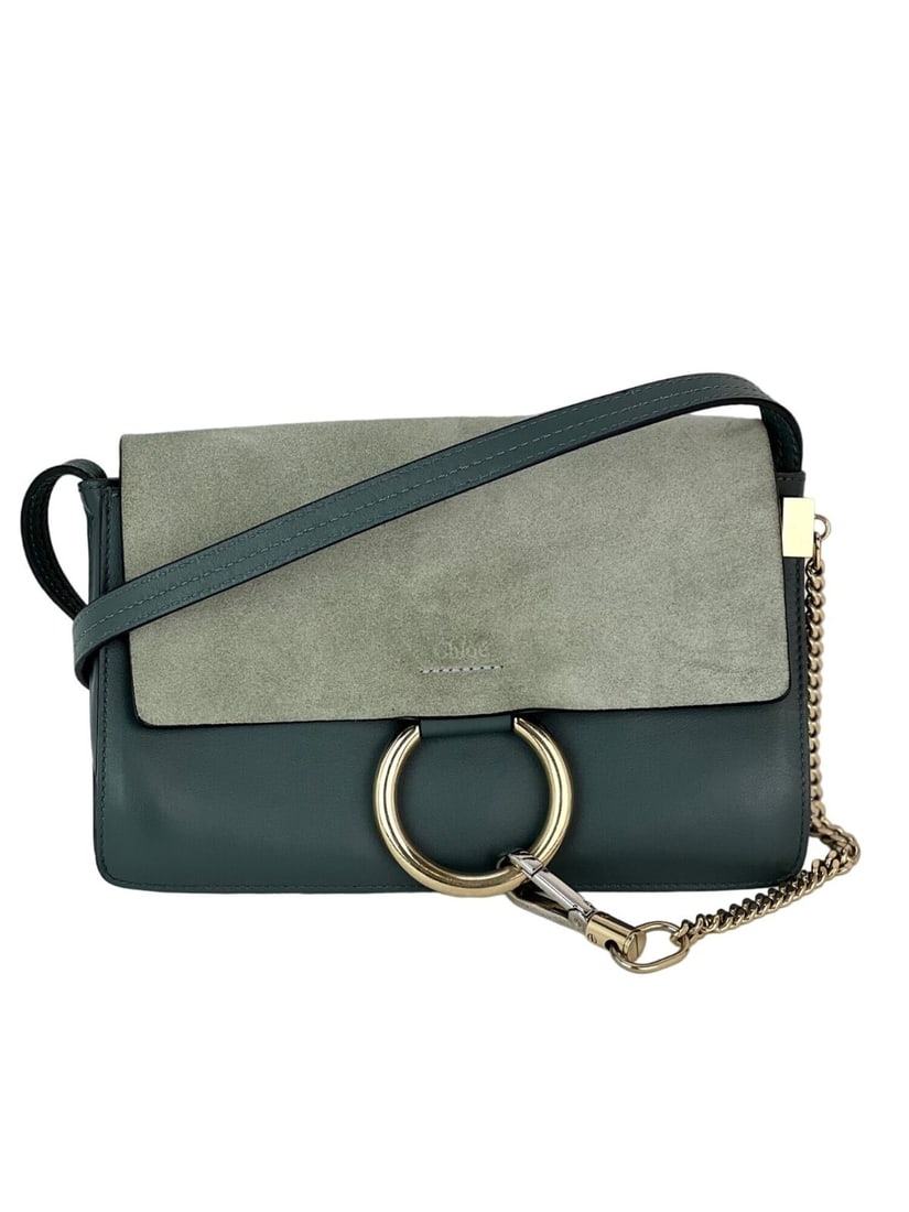 Chloe Faye Gray Blue Suede Leather Crossbody Bag: Chloe Faye Gray Blue Suede Leather Crossbody Bag Elevate your style with the Chloe Faye Chain Suede Leather Crossbody Bag, expertly crafted in Spain. This chic rectangular bag features a sophisticated