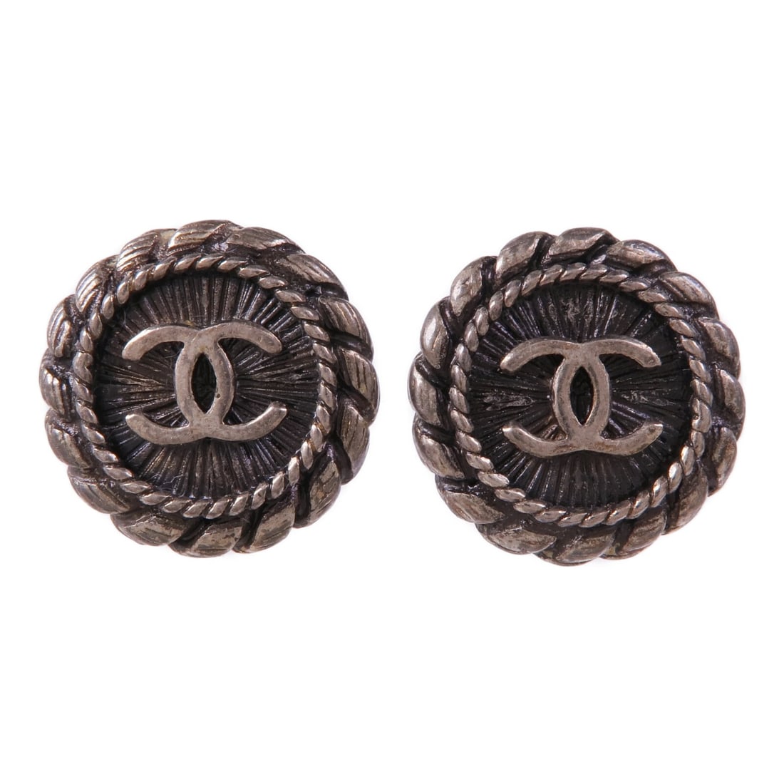 CHANEL Silver Metal Pierced Earrings Made in France: CHANEL Silver Metal Pierced Earrings Made in France Elevate your jewelry collection with these stunning CHANEL CC Pierced Earrings. Crafted with a sleek silver finish, these earrings effortlessly comb