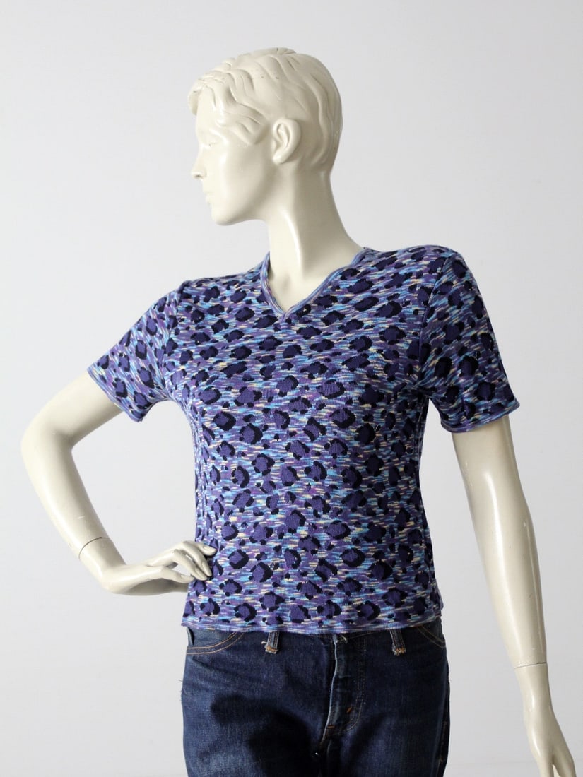 1980s Yves Saint Laurent Cropped Animal Print Blouse: 1980s Yves Saint Laurent Cropped Animal Print Blouse This vintage Yves Saint Laurent blouse from the 1980s embodies a chic, cropped design with a stylish v-neck. It showcases a striking blue and purpl