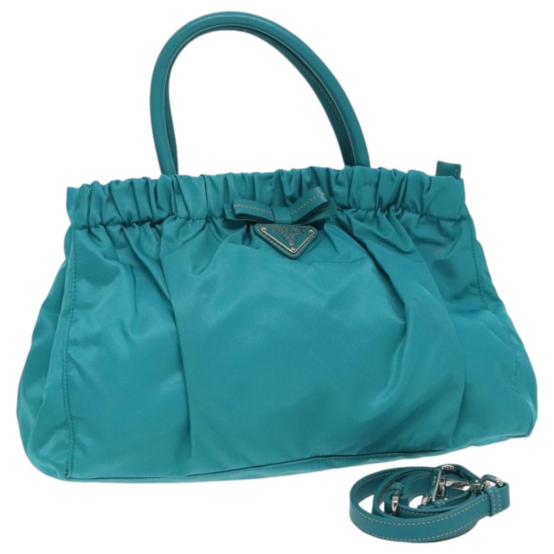 Turquoise Nylon Tote Prada Bow Convertible 30cm x 20cm x 11cm: Turquoise Nylon Tote Prada Bow Convertible 30cm x 20cm x 11cm This Prada Bow Convertible Tote in turquoise nylon is designed for women, featuring a clean pre-owned condition with minor signs of use in
