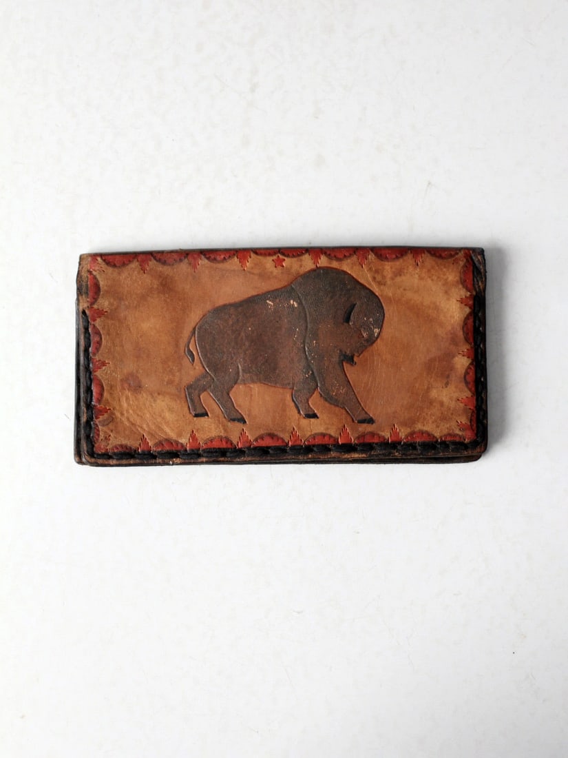 1970s Vintage Tooled Leather Wallet with Bison and Eagles: 1970s Vintage Tooled Leather Wallet with Bison and Eagles This Vintage 70s Tooled Leather Wallet showcases a unique design from the 1970s. Crafted from tan leather, it features a beautifully tooled im