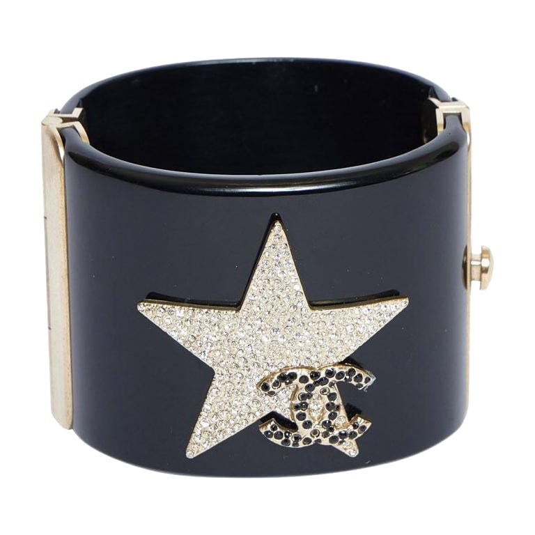 Chanel Black Lucite Cuff Bracelet Star Design with Rhinestones: Chanel Black Lucite Cuff Bracelet Star Design with Rhinestones Elevate your accessory collection with this stunning Chanel Black Lucite Cuff Bracelet. Crafted in Italy, this exquisite piece showcases