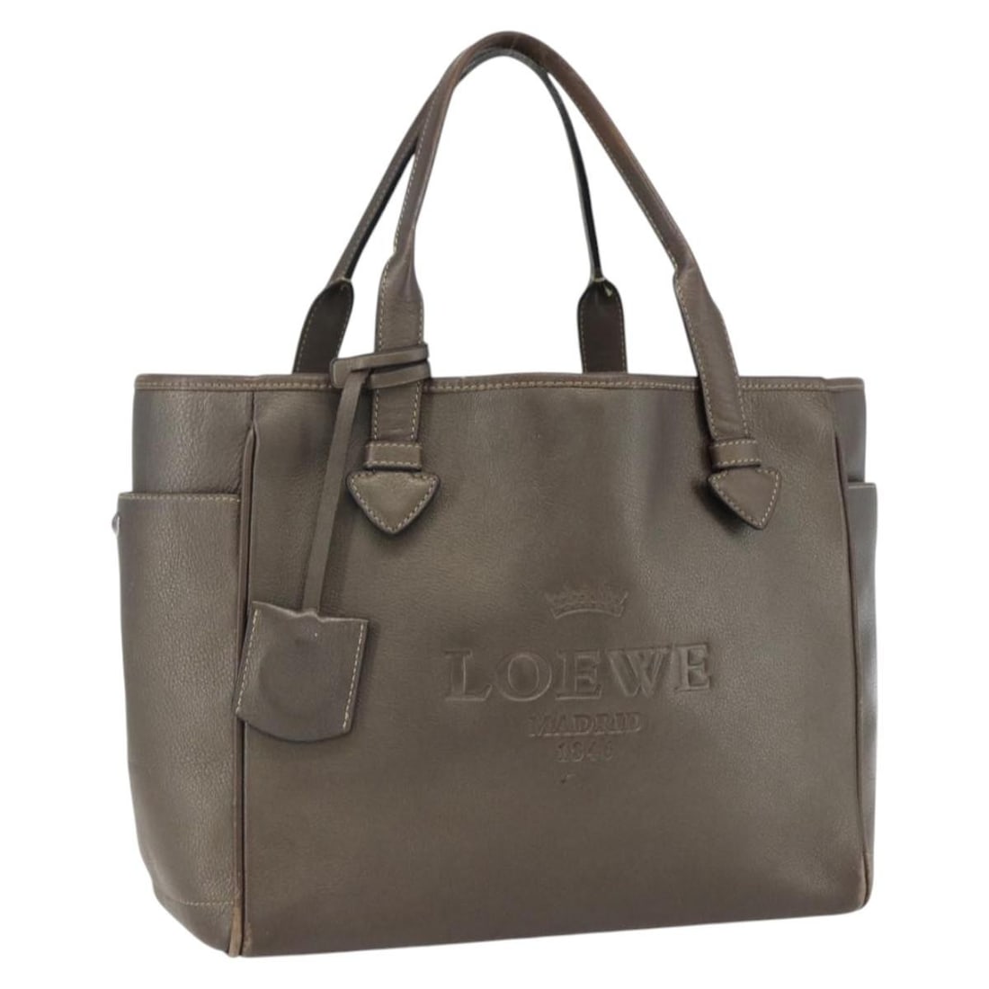 Loewe Heritage Brown Leather Tote Bag with Silver Accents Spain: Loewe Heritage Brown Leather Tote Bag with Silver Accents Spain This LOEWE Heritage tote bag is crafted from brown and silver leather and features a classic tote silhouette. It includes a clochette ac