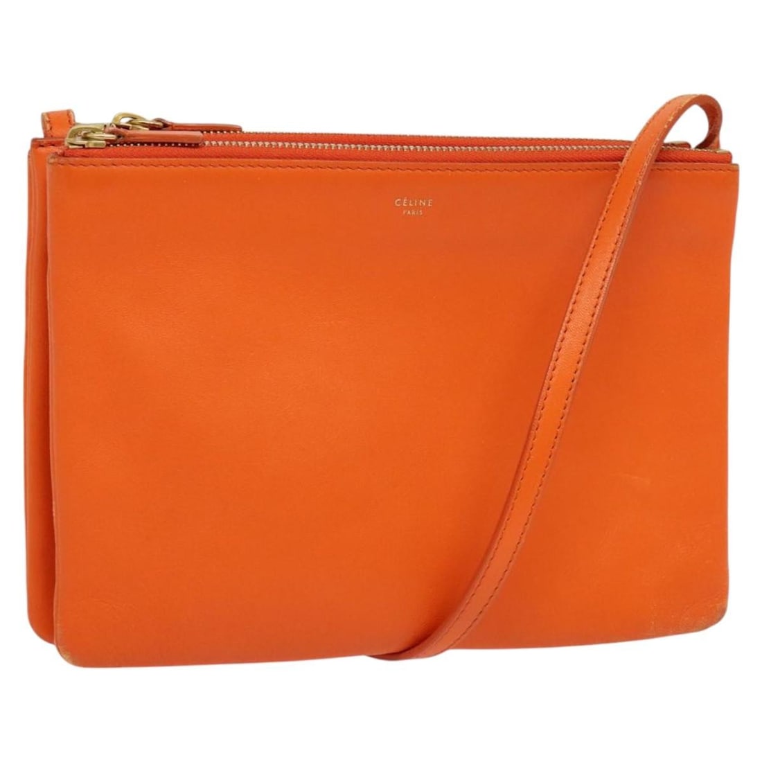 CELINE Trio Orange Leather Shoulder Bag Made in Italy: CELINE Trio Orange Leather Shoulder Bag Made in Italy The CELINE Trio Shoulder Bag is a stylish accessory crafted from high-quality leather in a vibrant orange hue. This bag measures approximately 7.1