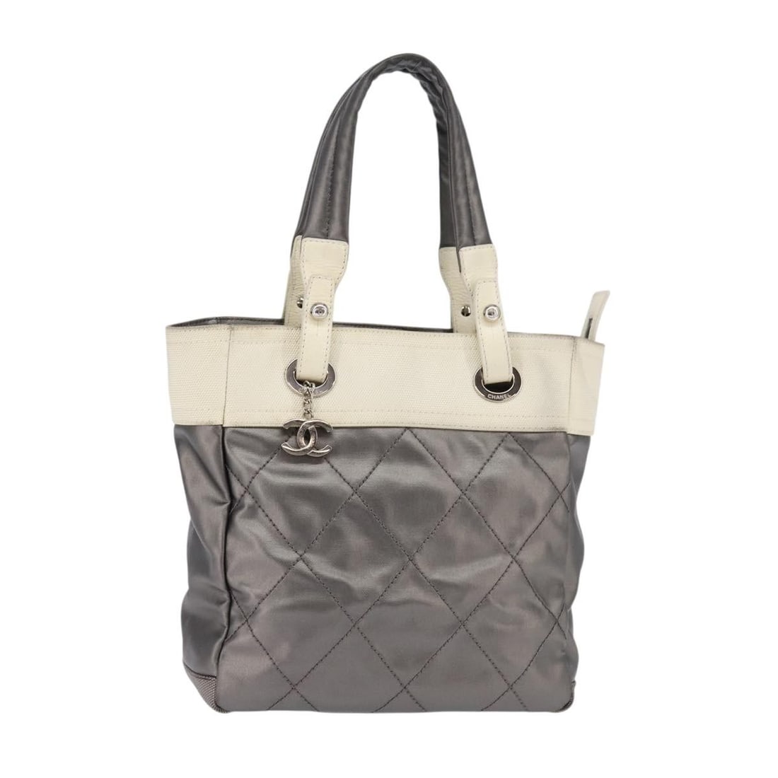 CHANEL Paris Biarritz Silver Tote Bag Coated Canvas Auth: CHANEL Paris Biarritz Silver Tote Bag Coated Canvas Auth This authentic CHANEL Paris Biarritz Tote Bag is crafted from durable coated canvas in a sophisticated silver hue. It features a spacious inter