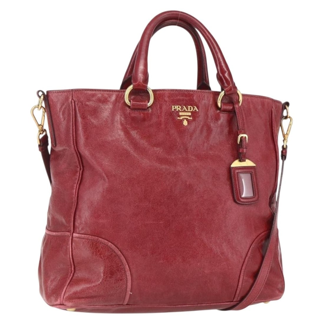 Red Leather Prada Convertible Handbag with Shoulder Strap and Name Tag: Red Leather Prada Convertible Handbag with Shoulder Strap and Name Tag This PRADA 2-way handbag features a red and gold leather exterior and can be carried by hand or with a shoulder strap. It is made