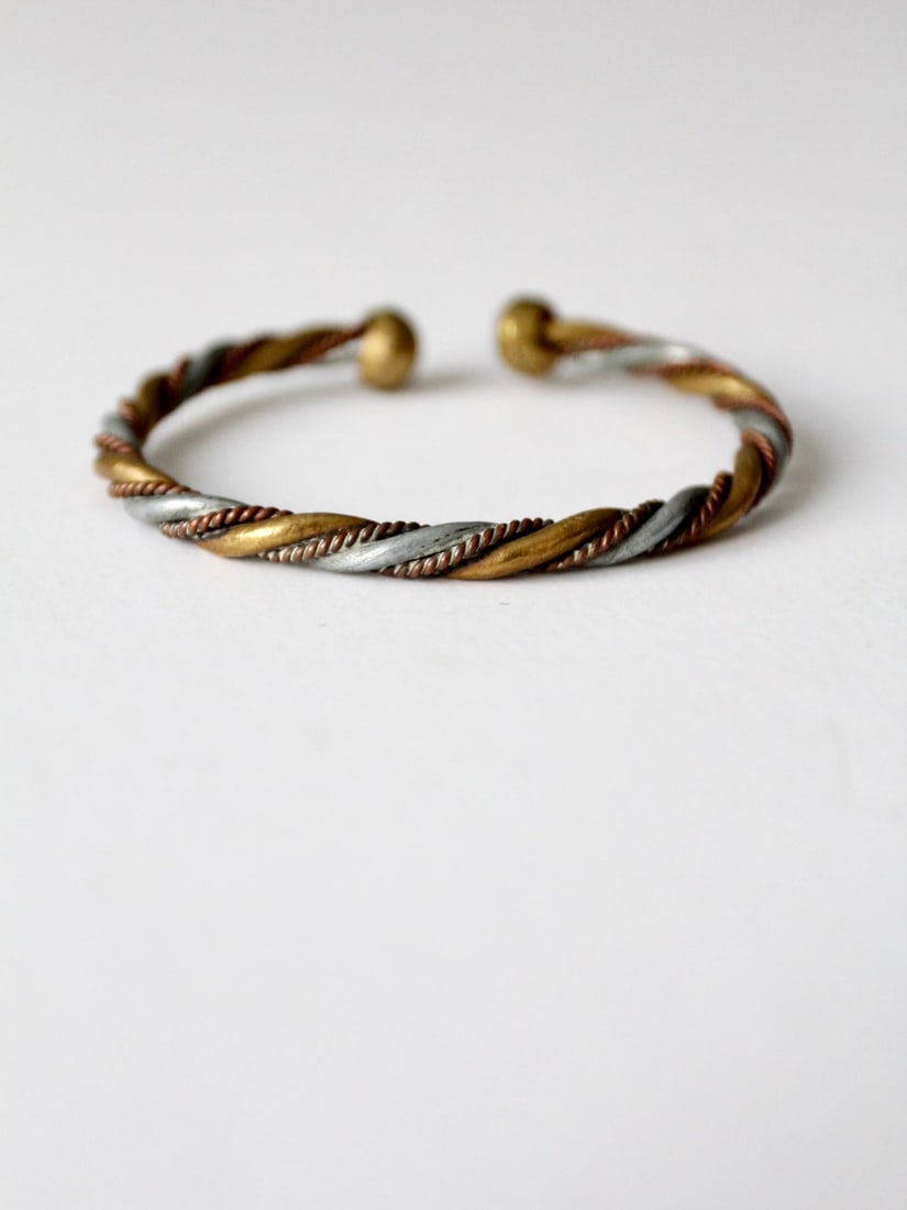 1970s Vintage Mixed Metal Twisted Rope Cuff Bracelet: 1970s Vintage Mixed Metal Twisted Rope Cuff Bracelet This vintage 1970s mixed metal cuff bracelet showcases a unique twisted rope design crafted from copper, brass, and pewter. The cuff is in good con