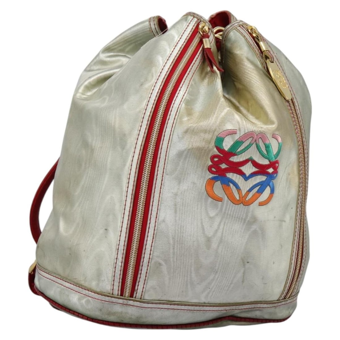 LOEWE Anagram Silver PVC Leather Backpack Made in Italy: LOEWE Anagram Silver PVC Leather Backpack Made in Italy This LOEWE Anagram Backpack is crafted from durable PVC leather in a striking silver color. With a height of approximately 13.0 inches (33 cm),