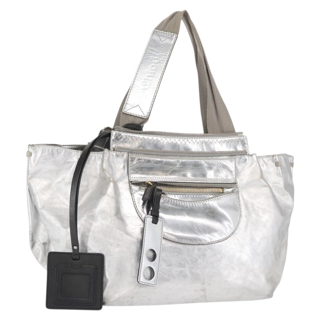 Silver Leather Tote by Chloe with 13 Inch Width and 8.7 Inch Handle Drop: Silver Leather Tote by Chloe with 13 Inch Width and 8.7 Inch Handle Drop This is a Chloe tote bag crafted from silver leather, featuring dual top handles. The bag is made in Romania and includes no ad