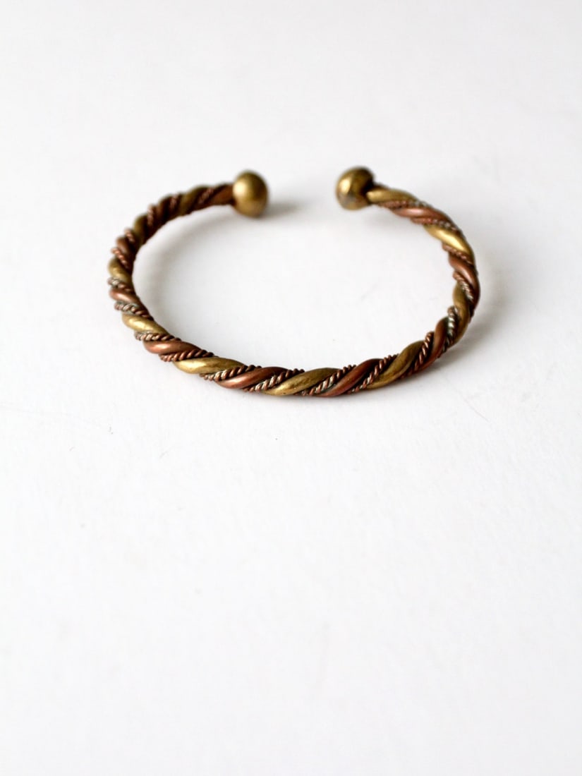 1970s Mexicana Copper Brass Twisted Braid Cuff Bracelet: 1970s Mexicana Copper Brass Twisted Braid Cuff Bracelet This vintage cuff bracelet, crafted from copper and brass, hails from the 1970s and showcases a distinctive Mexicana style. It features a beauti