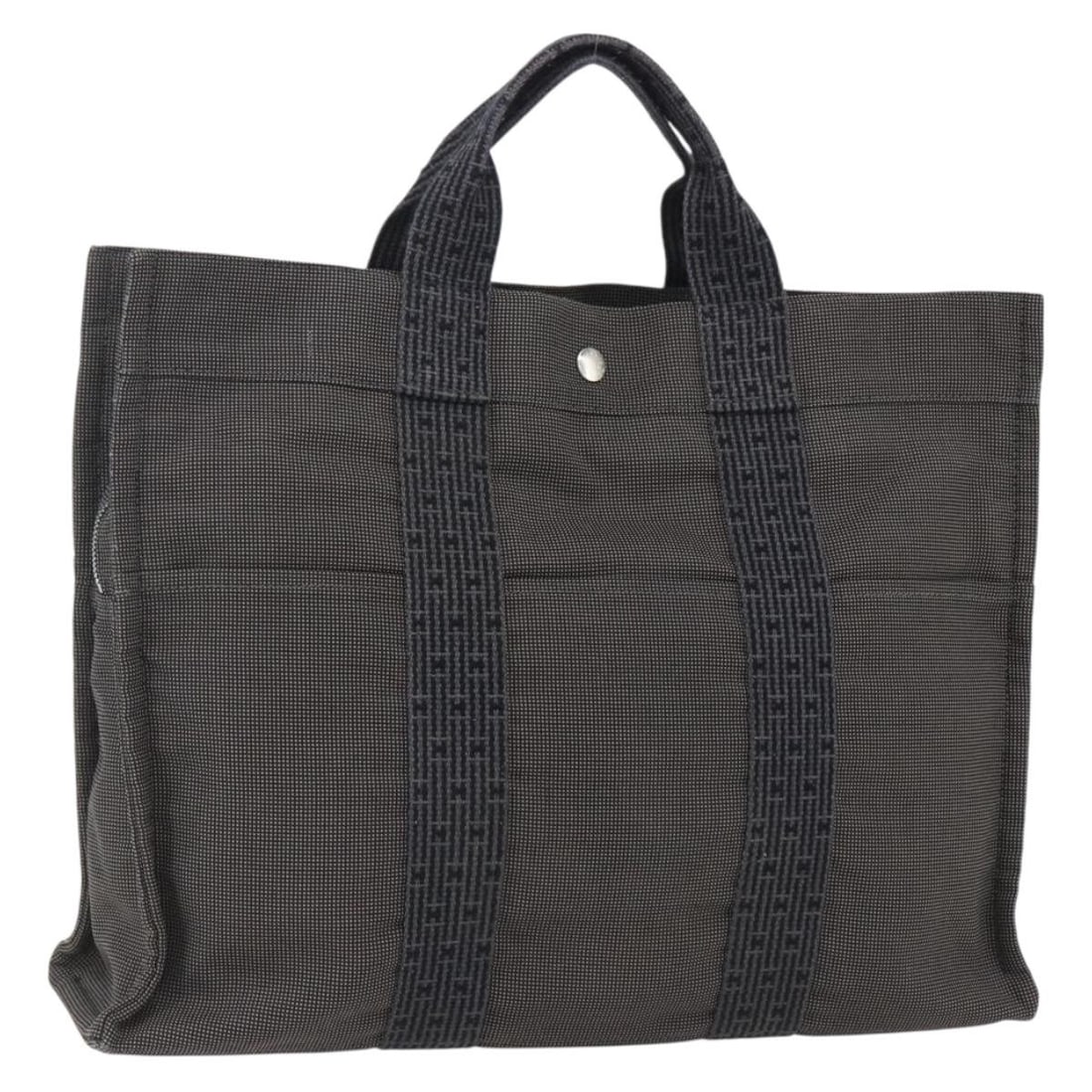 Her Line MM Canvas Gray Silver Tote Bag by Hermes: Her Line MM Canvas Gray Silver Tote Bag by Hermes This is a Hermes Her Line Tote MM hand bag crafted from gray and silver canvas. The bag features dual handles and a spacious interior, suitable for ev
